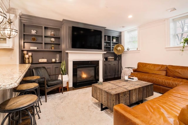 living room featuring a fireplace with flush hearth, recessed lighting, and visible vents