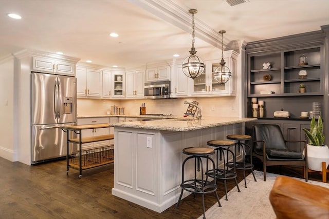 kitchen featuring a peninsula, white cabinets, dark wood-type flooring, and appliances with stainless steel finishes