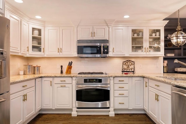 kitchen with a sink, dark wood-type flooring, appliances with stainless steel finishes, and white cabinetry