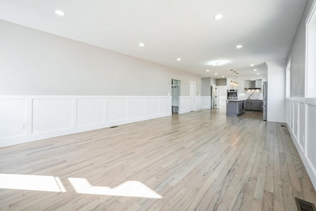 1 Falcon Dr, Shrewsbury, MA 01545 - unfurnished living room featuring a decorative wall, light wood-type flooring, recessed lighting, and wainscoting