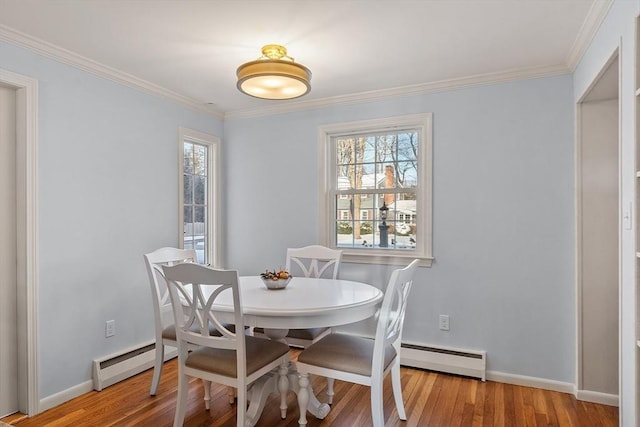 dining space with ornamental molding, light hardwood / wood-style floors, and baseboard heating