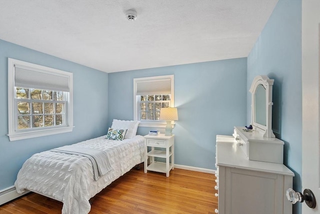 bedroom featuring light hardwood / wood-style flooring and baseboard heating