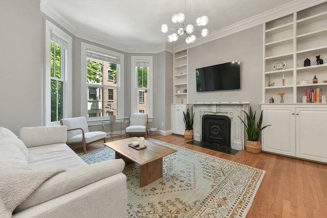 living room featuring built in shelves, light wood-style flooring, and ornamental molding