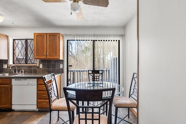 kitchen with sink, backsplash, a textured ceiling, ceiling fan, and dishwasher