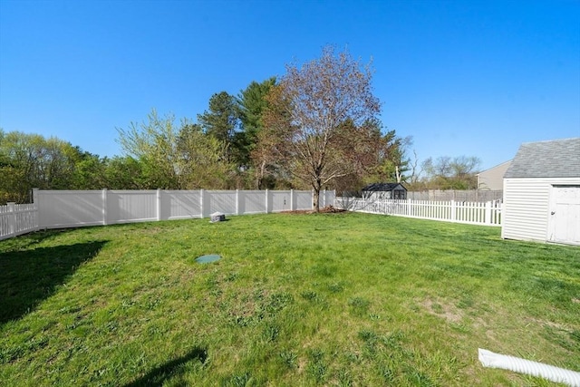 view of yard with a storage unit, a fenced backyard, and an outdoor structure