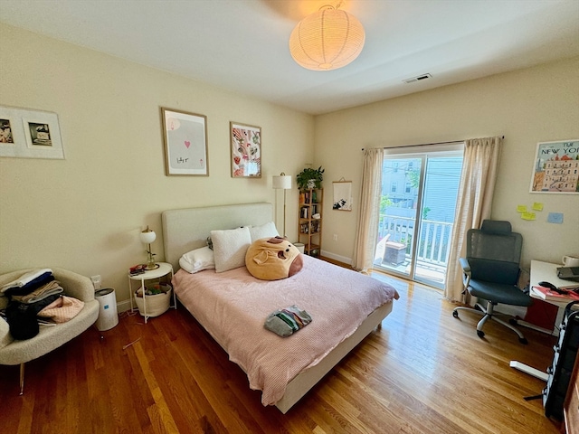 bedroom featuring access to exterior and wood-type flooring