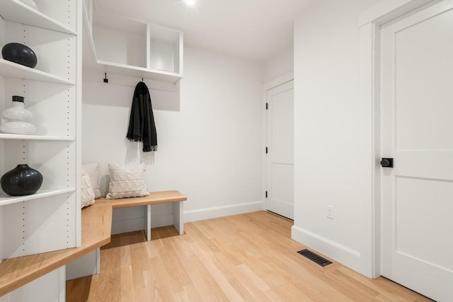 mudroom with light wood-style floors, baseboards, and visible vents