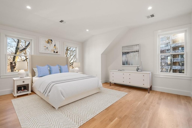 bedroom with visible vents, light wood finished floors, and multiple windows