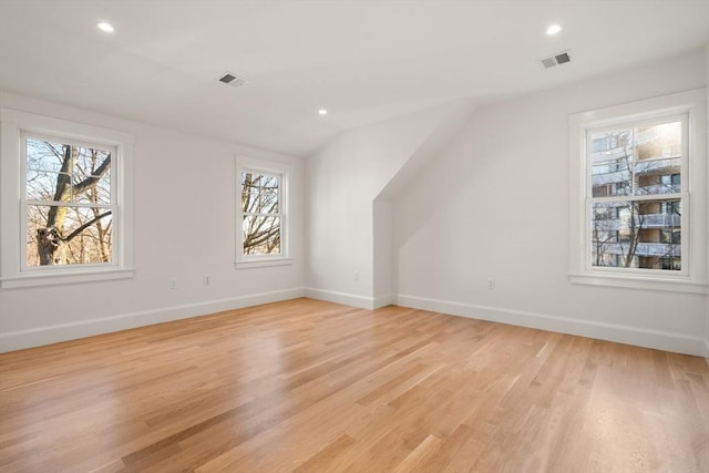 bonus room featuring light wood-type flooring, baseboards, and visible vents