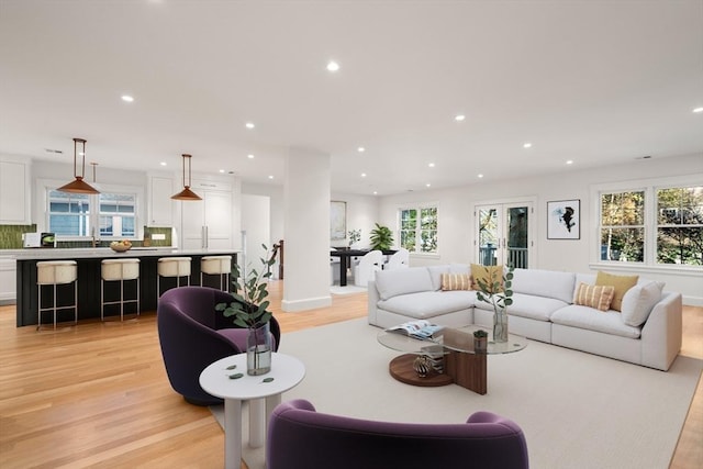 living area featuring light wood-style floors, recessed lighting, and a healthy amount of sunlight