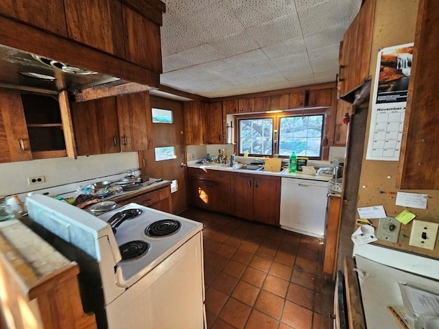 kitchen with dark tile patterned floors and white appliances