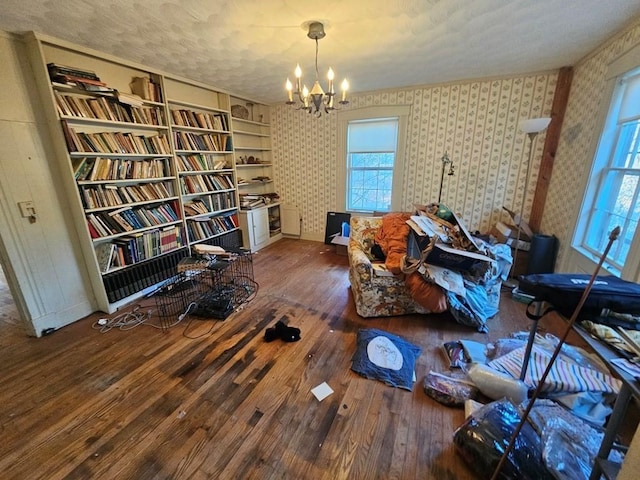 sitting room with dark hardwood / wood-style flooring, built in features, a textured ceiling, and a chandelier