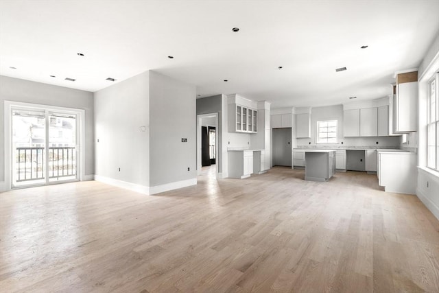 unfurnished living room with light wood-style flooring and baseboards