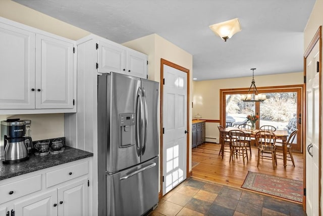 kitchen with white cabinetry, hanging light fixtures, a baseboard heating unit, and stainless steel refrigerator with ice dispenser