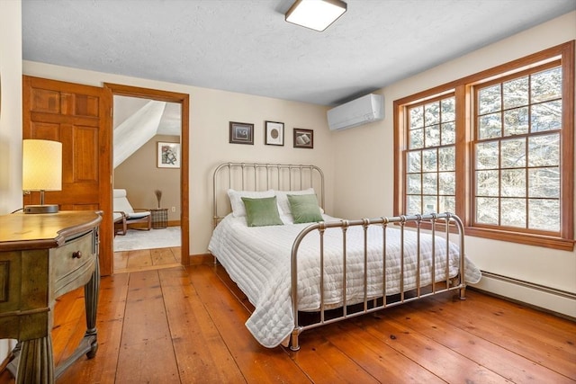 bedroom with lofted ceiling, hardwood / wood-style flooring, and a wall mounted AC