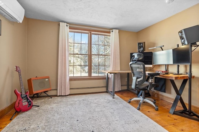 office area featuring hardwood / wood-style floors, plenty of natural light, a wall mounted AC, and a textured ceiling