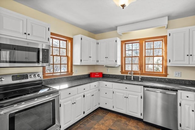 kitchen featuring appliances with stainless steel finishes, sink, and white cabinets