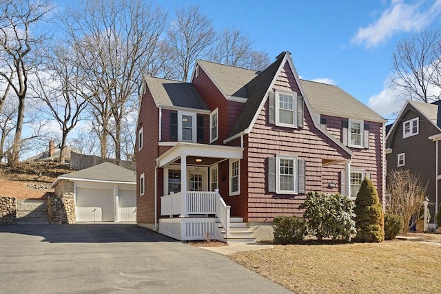 view of front of house featuring a garage, roof with shingles, and an outdoor structure