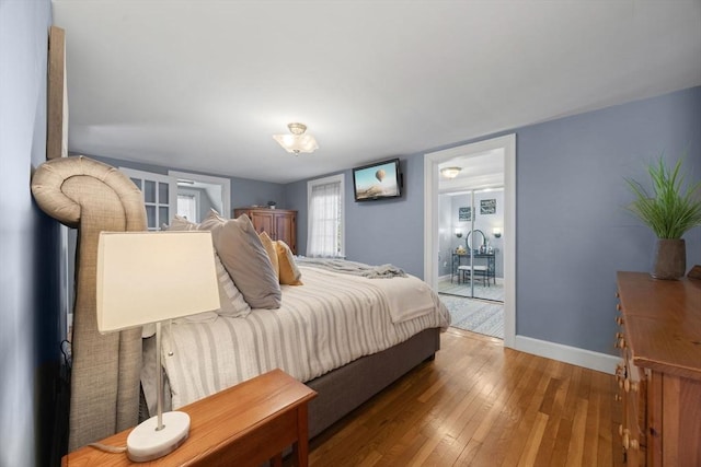 bedroom with baseboards and hardwood / wood-style floors