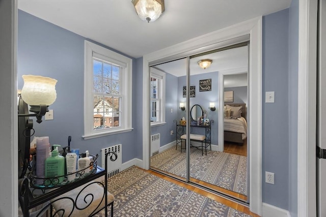 interior space featuring radiator heating unit, baseboards, and wood finished floors