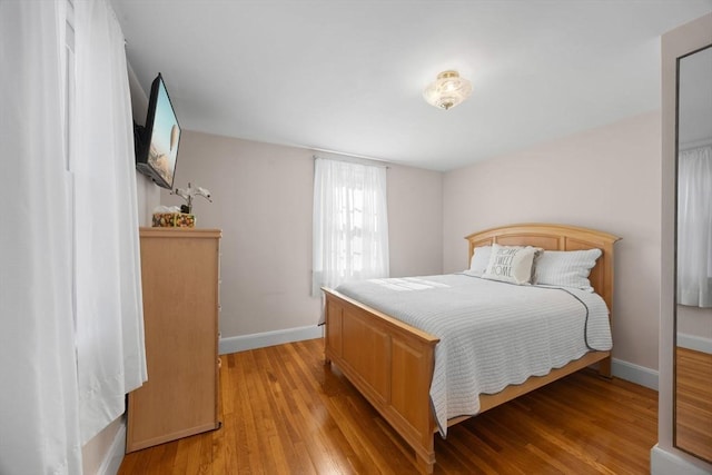 bedroom featuring baseboards and light wood finished floors