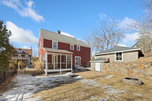 rear view of house with a patio, a chimney, an outdoor fire pit, a sunroom, and fence