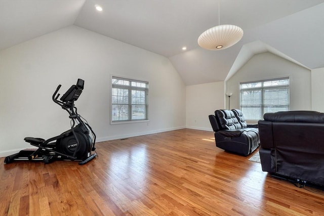 exercise area with plenty of natural light, light wood-type flooring, baseboards, and vaulted ceiling