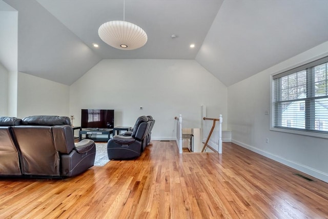 interior space with vaulted ceiling, light wood-style flooring, baseboards, and visible vents