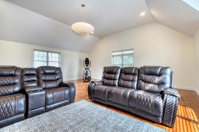 living area with vaulted ceiling, wood finished floors, and baseboards