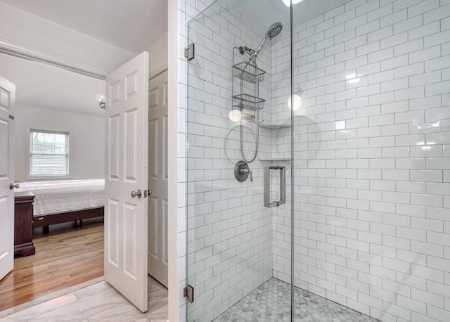 ensuite bathroom with marble finish floor, a stall shower, and ensuite bathroom