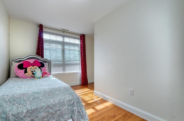 bedroom with light wood-type flooring and baseboards