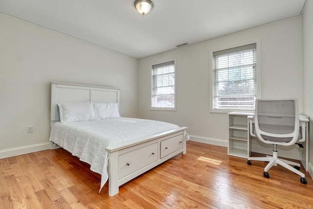 bedroom with visible vents, baseboards, and light wood-style floors