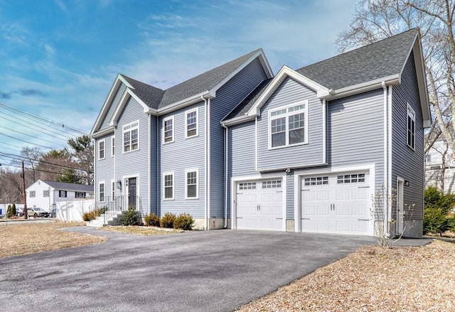 view of front of home featuring an attached garage, roof with shingles, and driveway