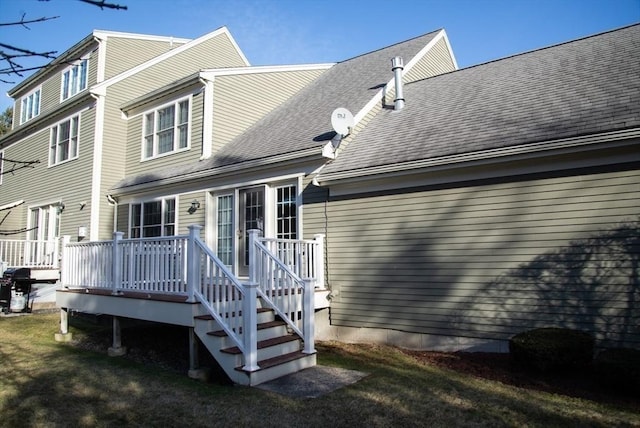 rear view of house featuring a lawn and a wooden deck