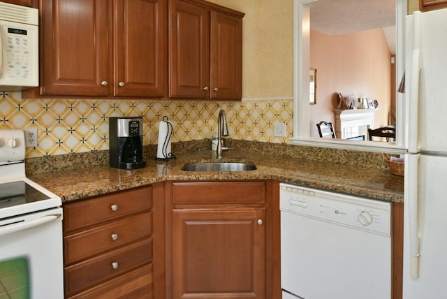 kitchen with tasteful backsplash, sink, dark stone counters, and white appliances