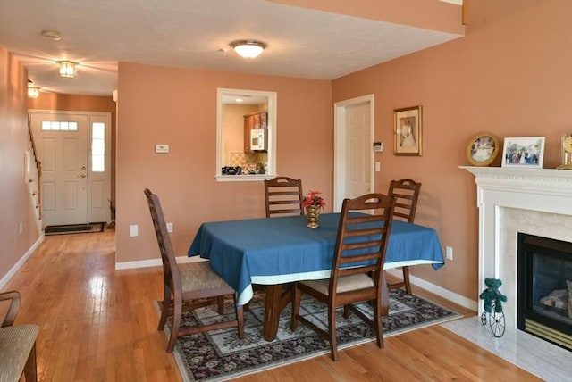 dining room with hardwood / wood-style floors and a tile fireplace