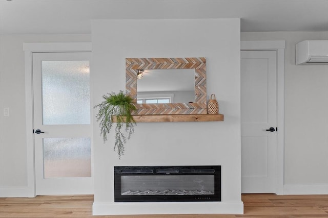 30 Cable Ave Unit B, Salisbury, MA 01952 - detailed view of a wall mounted AC, wood finished floors, and a glass covered fireplace