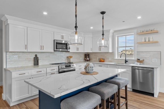 30 Cable Ave Unit B, Salisbury, MA 01952 - kitchen featuring stainless steel appliances, light wood-style flooring, white cabinets, a breakfast bar, and recessed lighting