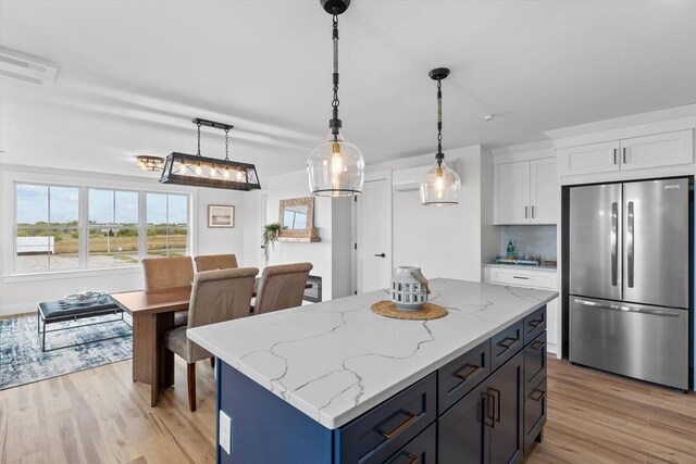 30 Cable Ave Unit B, Salisbury, MA 01952 - kitchen featuring freestanding refrigerator, light wood finished floors, white cabinets, pendant lighting, and tasteful backsplash