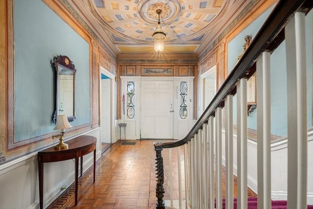 entryway with ornamental molding, stairway, and a decorative wall