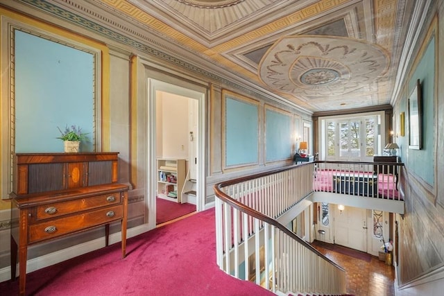 hall with an upstairs landing and crown molding