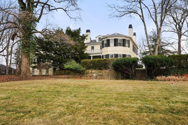 rear view of property with a yard and a chimney