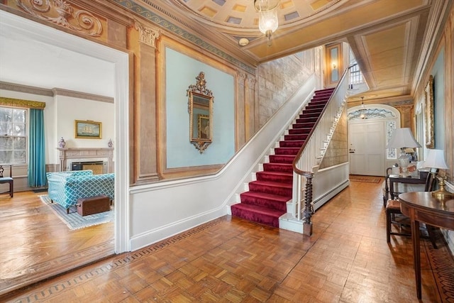 stairs featuring crown molding, baseboards, a fireplace, and baseboard heating