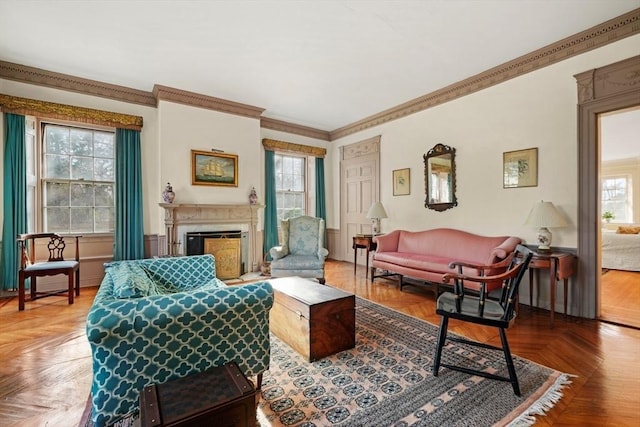 living area with healthy amount of natural light, ornamental molding, and a fireplace