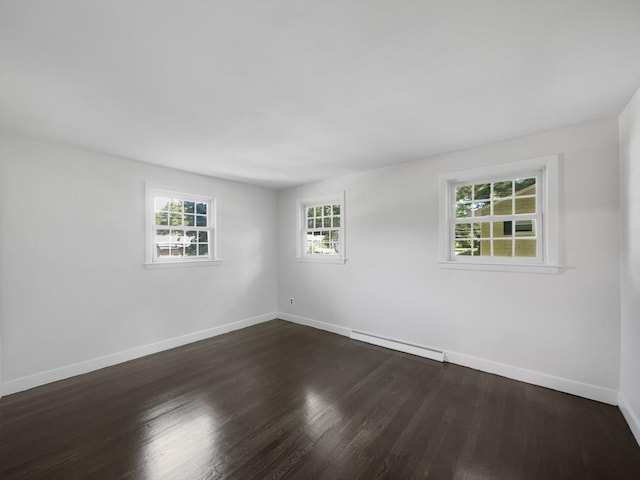 empty room with dark wood-type flooring and a baseboard radiator