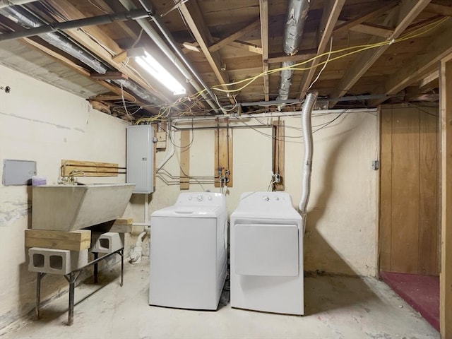 laundry room featuring electric panel, washer and clothes dryer, and sink