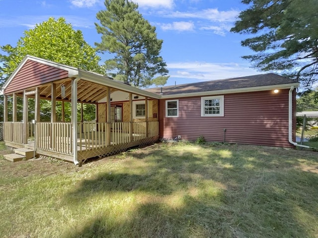 rear view of property with a lawn and a wooden deck