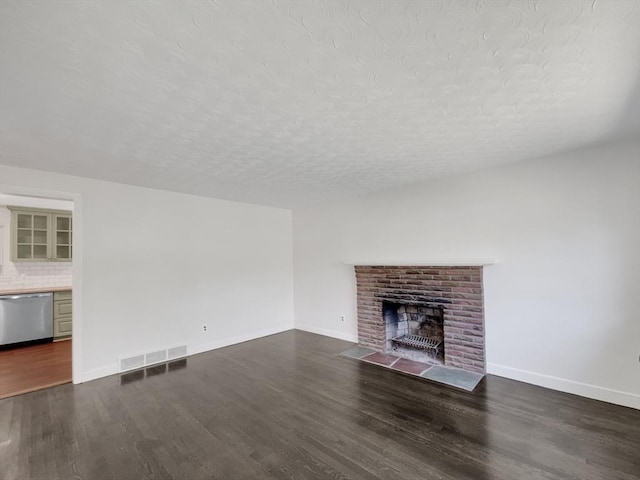 unfurnished living room with dark hardwood / wood-style floors and a brick fireplace