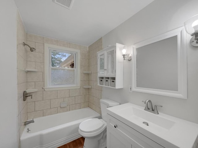 full bathroom featuring vanity, wood-type flooring, tiled shower / bath combo, and toilet