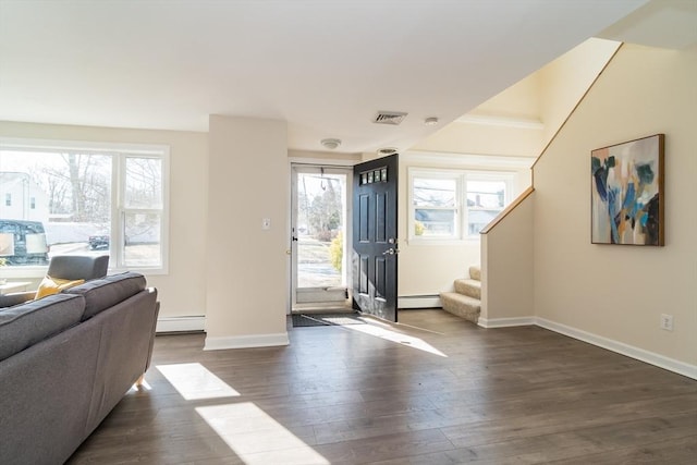 entrance foyer with stairs, dark wood finished floors, visible vents, and baseboard heating